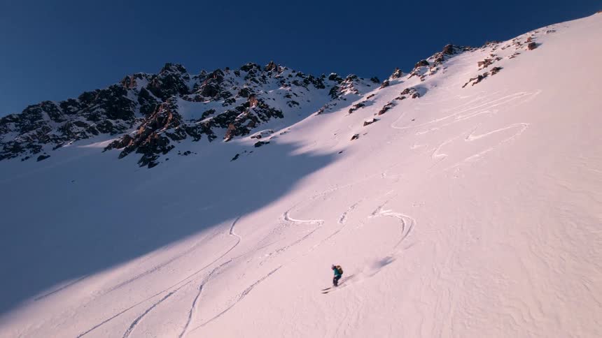 Two people are skiing together on the mountain slope
