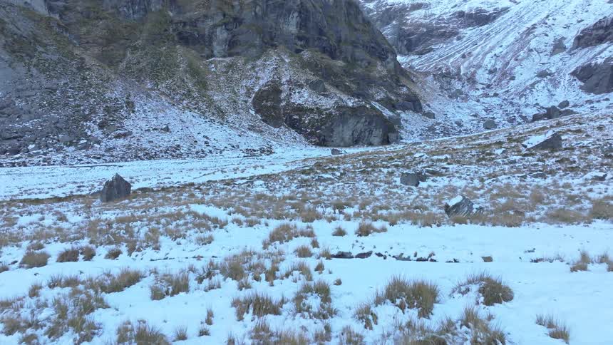A large snowy field bordered by mountains