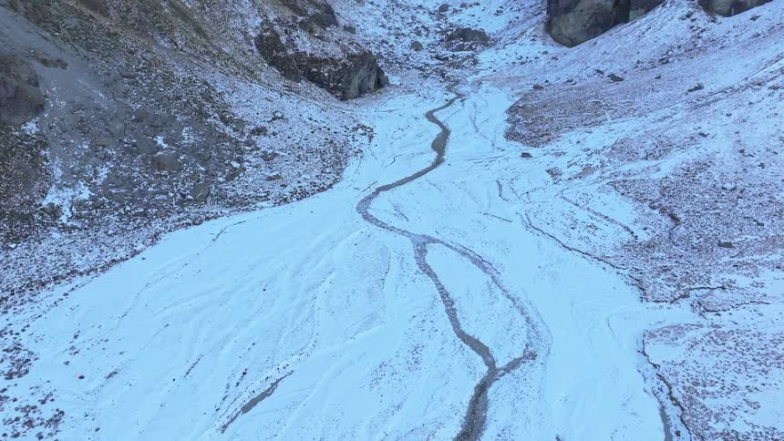 A small stream is flowing from the mountain slope