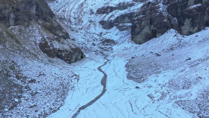 The frozen stream runs between the mountains