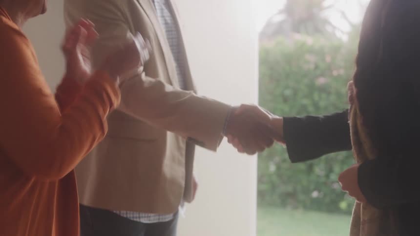 A person hands over a set of keys to a couple symbolizing a property transaction or new homeownership