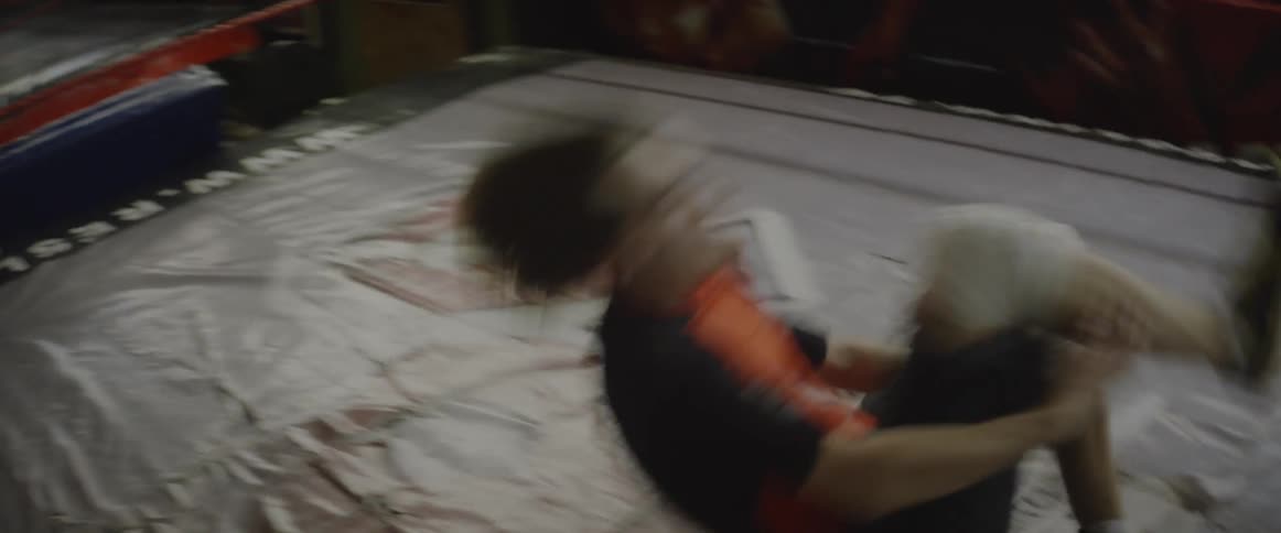 A wrestler tumbles forward in the ring