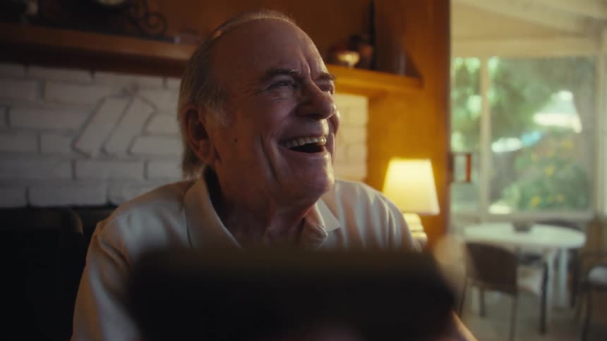 Elderly man sitting and laughing