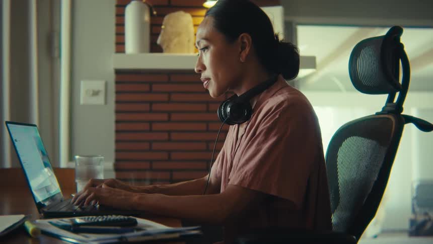 The woman is typing on her laptop at home