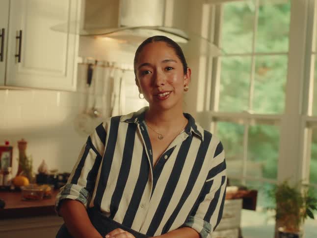 A smiling woman standing in her kitchen