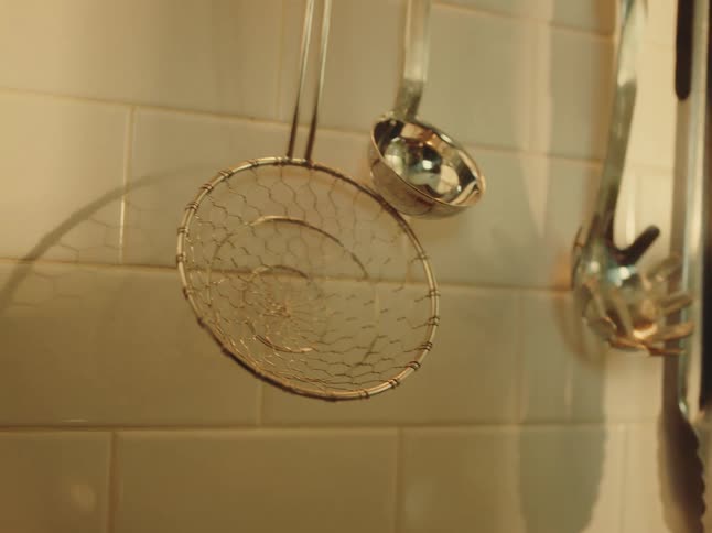 Cooking utensils on a white tile wall