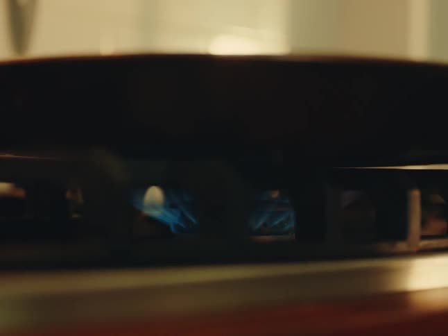 Stove top burner ignites under a pan