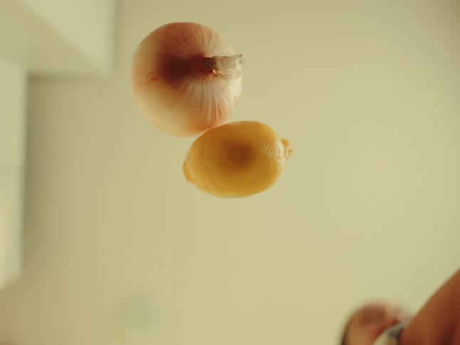 Fruits and vegetables being spread on a transparent surface