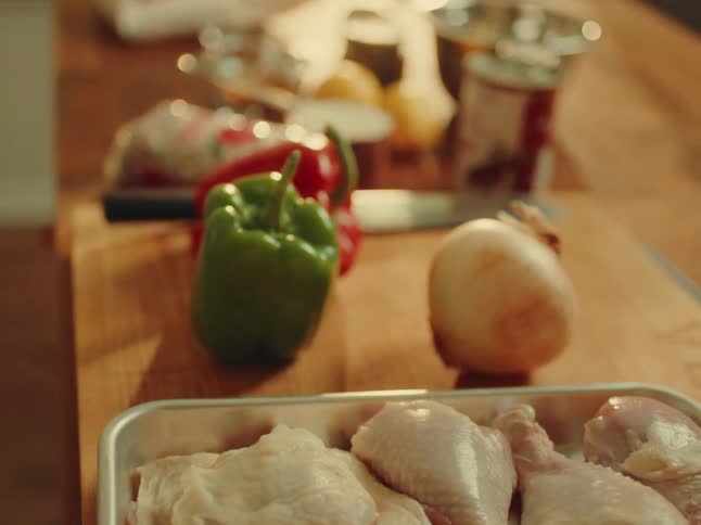 The image displays various cooking ingredients neatly arranged on a wooden surface including a bag of paella rice lemons spices in small glass bowls and a measuring cup full of rice the setting suggests a culinary preparation