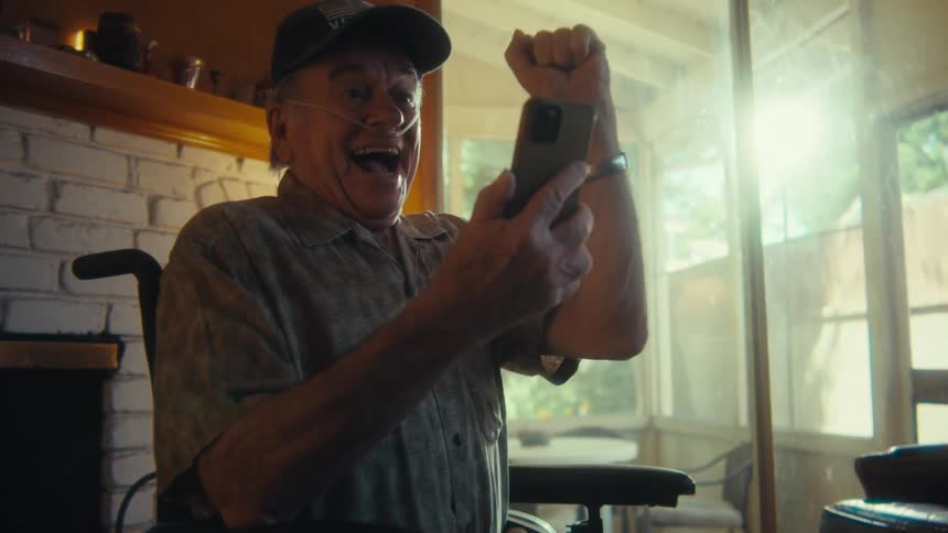 A man is excited by something he sees on his phone