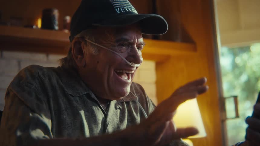 A man happily talks on his phone