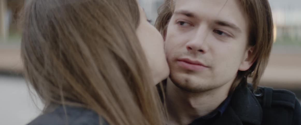 A man and woman are giving each other kisses and talking