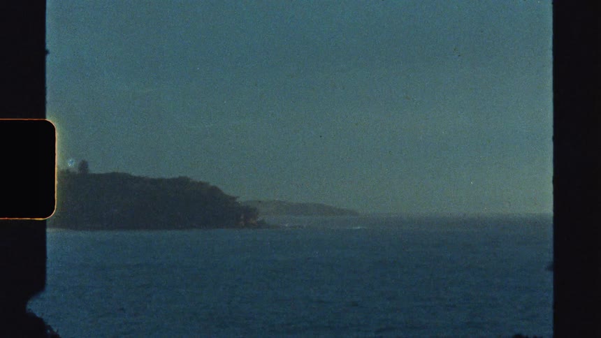 An island covered in green vegetation surrounded by the ocean at sun down