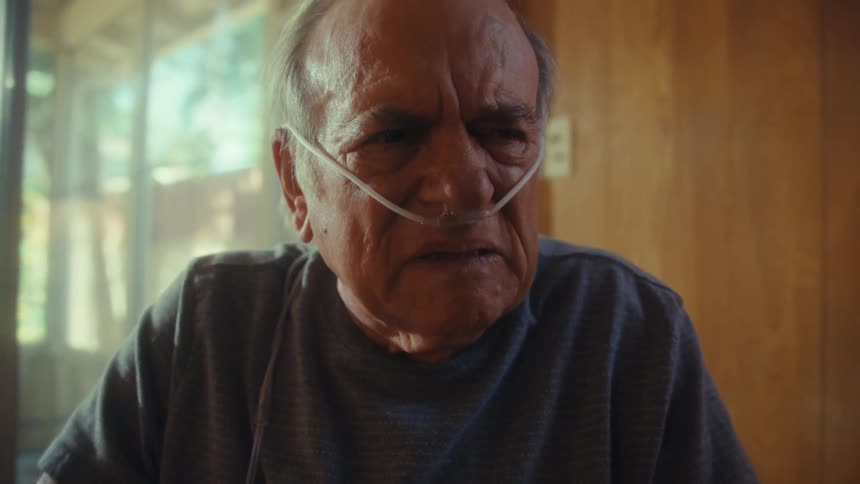 The man removes his glasses looking angry