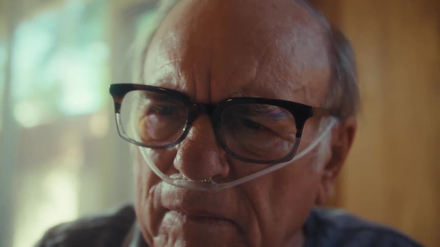 Concentrated elderly man with glasses reading a document
