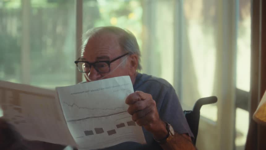 The man reads some paperwork then cheers