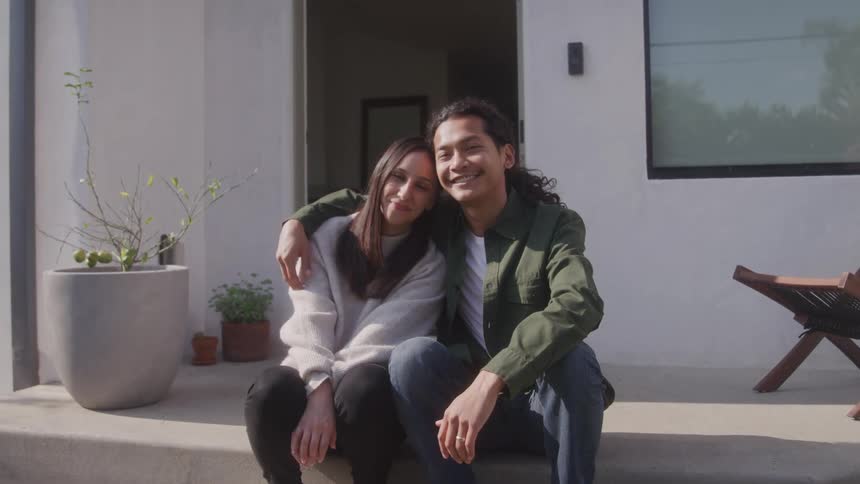 Couple sitting in the backyard hugging each other happily