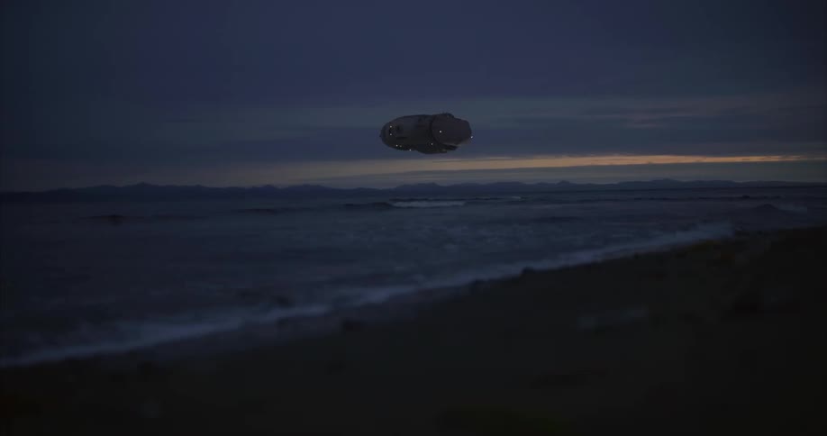 A mysterious cylindrical object with glowing elements hovers low over a body of water at what appears to be dusk or dawn the sky above is dark with hints of light on the horizon and faint outlines of distant land can be seen