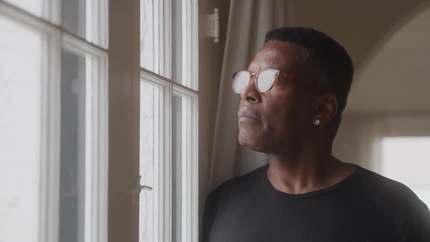 Man with glasses looking out the window