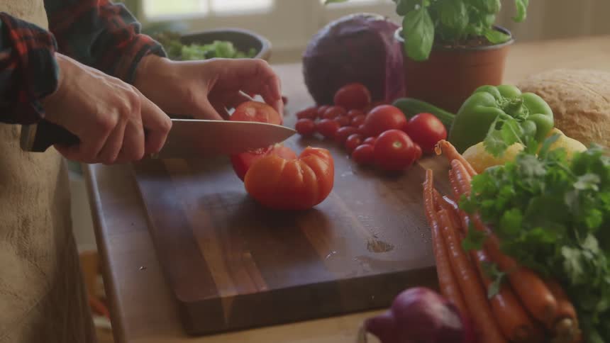 A person slices a tomato