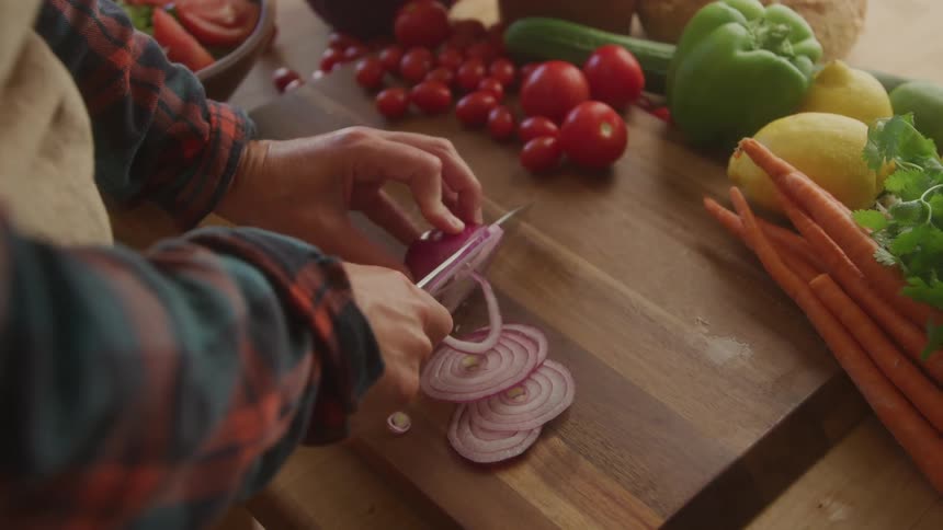 A person slices an onion