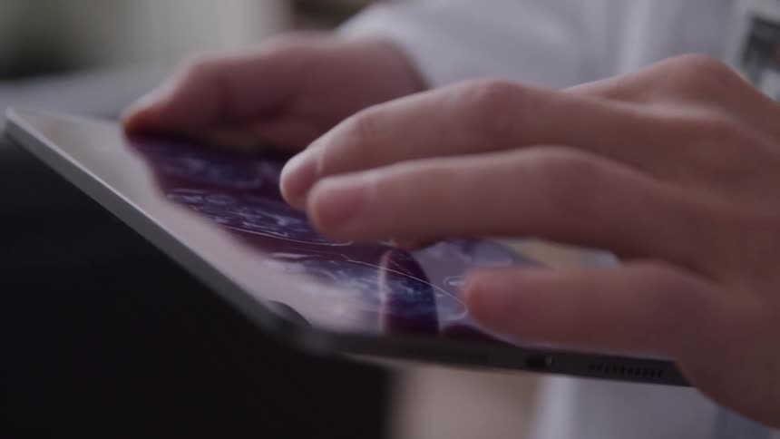 Pair of hands touching a tablet screen