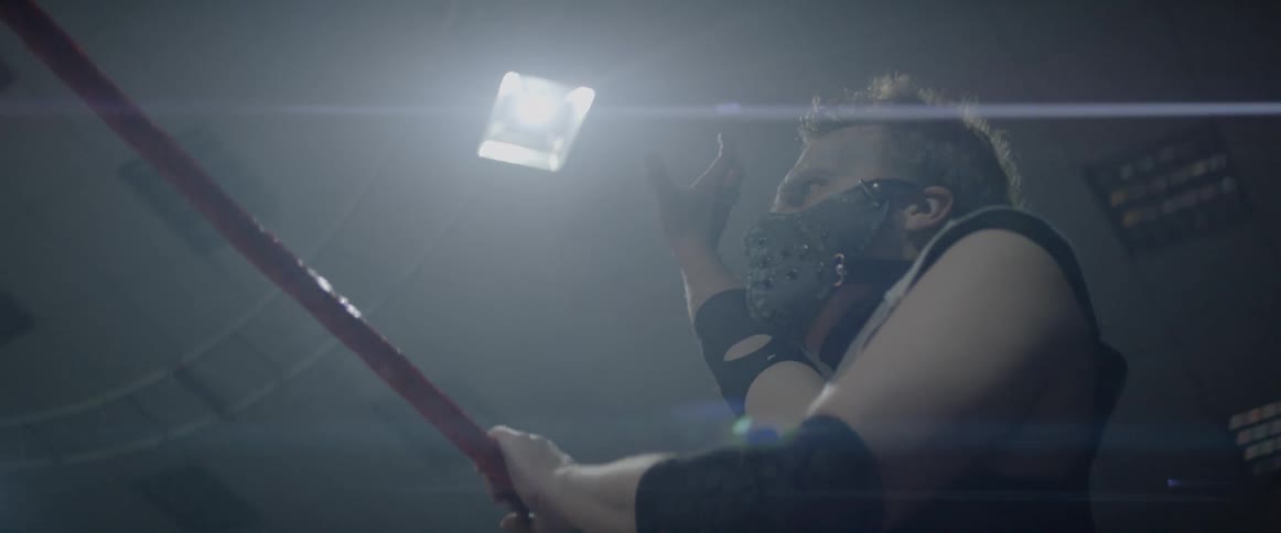 A man reaching for a light as he holds onto a rope of a ring