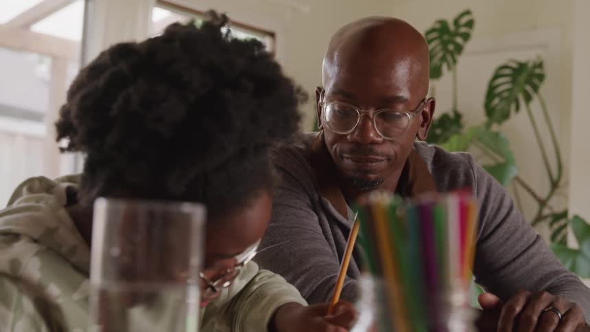 Father and daughter clapping their hands while sitting at a table