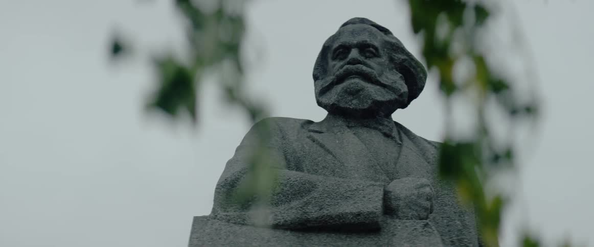 A statue stands in front of a tree