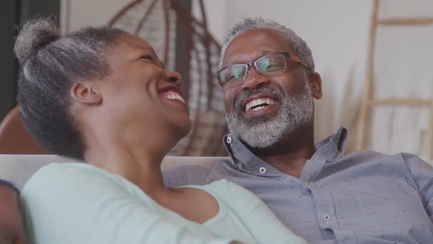 Couple sitting together hugging each other talking and smiling
