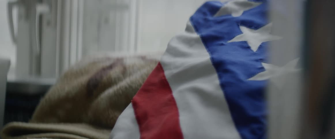 A flag patterned pillow on a bed