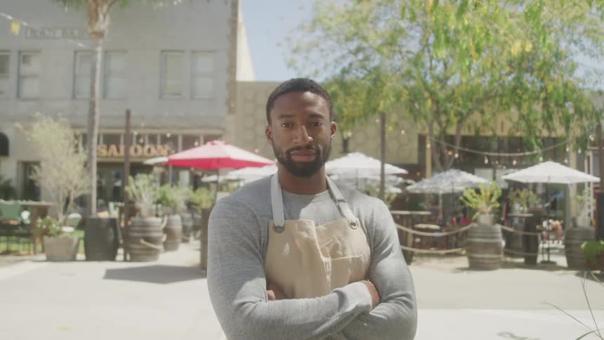 Portrait of a young black male chef standing outdoors in a city during daytime