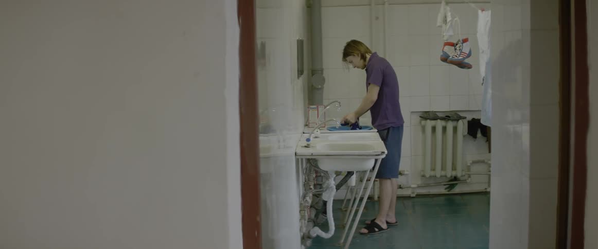A man washes clothing in a sink