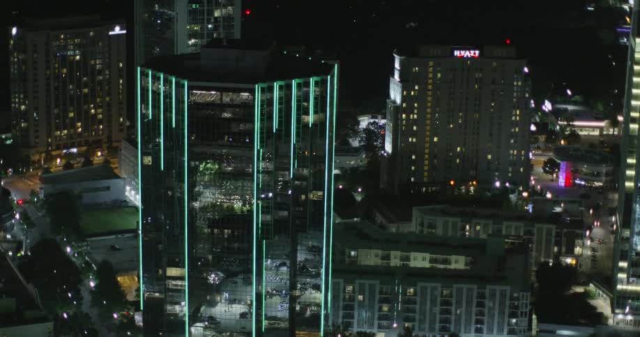 The design of a high-rise is enhanced by green lights lit up at night
