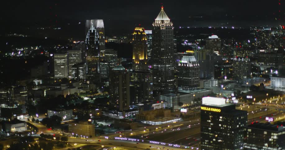 The city below is brightly lit at night