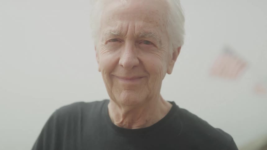Close up portrait of an elderly man standing outdoors during daytime