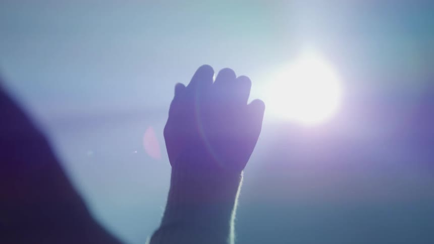 Persons hand towards an abstract light