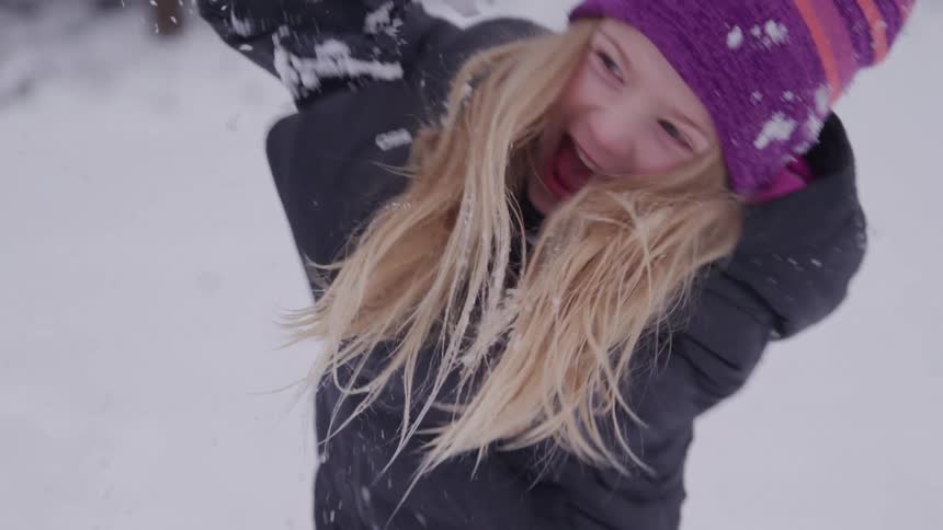 A girl throws a snowball