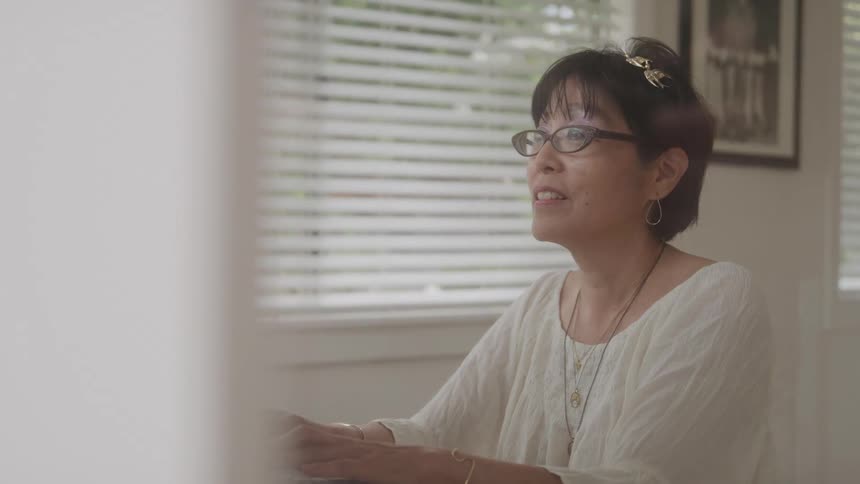 Lady sitting typing on a computer keyboard