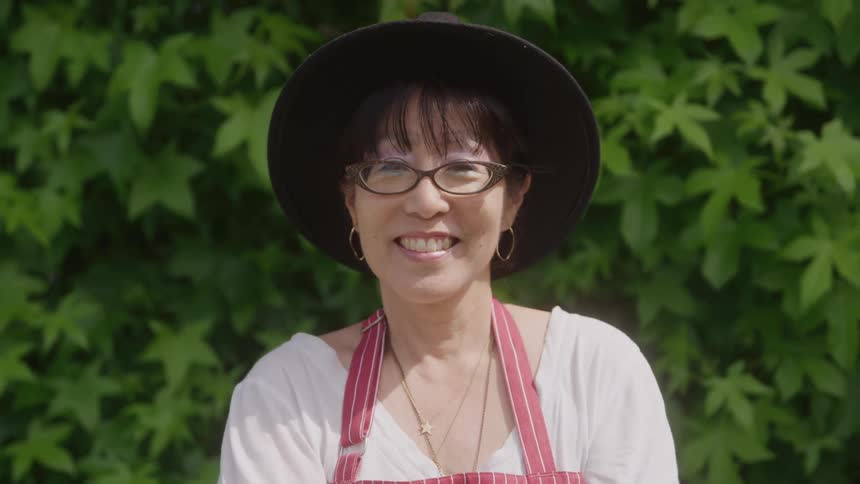 Woman in hat outdoors with happy expression