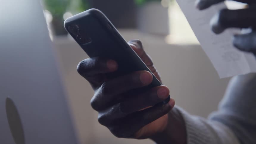 Hand holding and typing on a smartphone