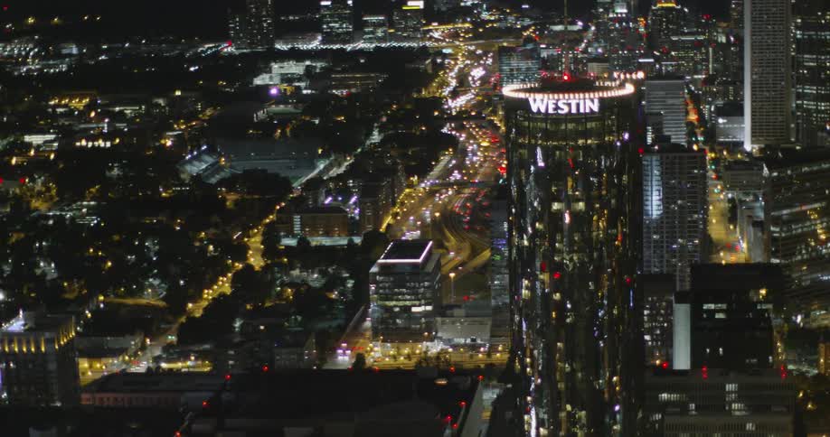 Traffic flows through a city lit by many lights at night