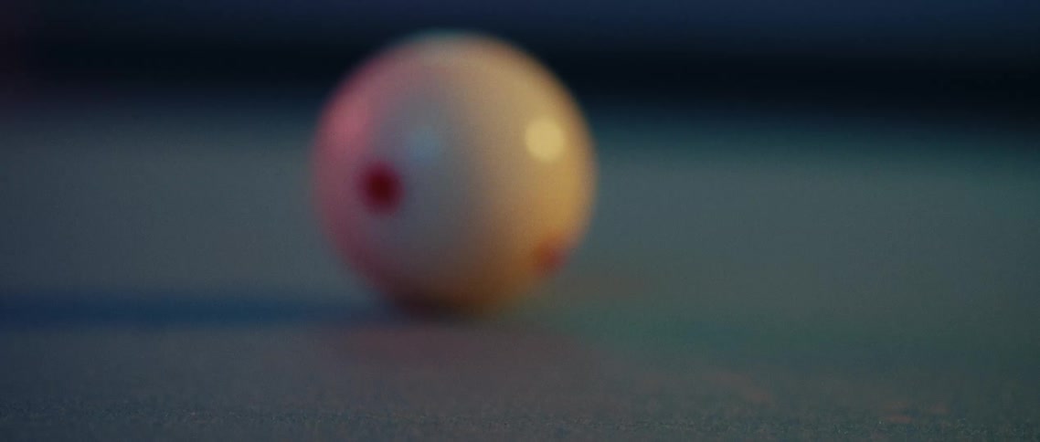 A stick hits a white pool ball causing it to hit another ball as it rolls backward afterward