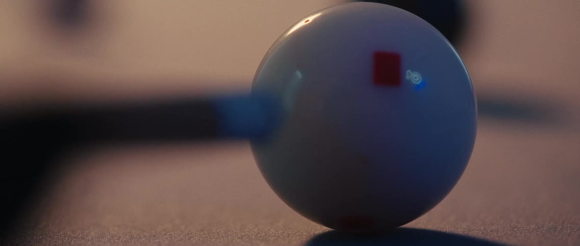 Pool cue strikes the cue ball sending it rolling across the pool table