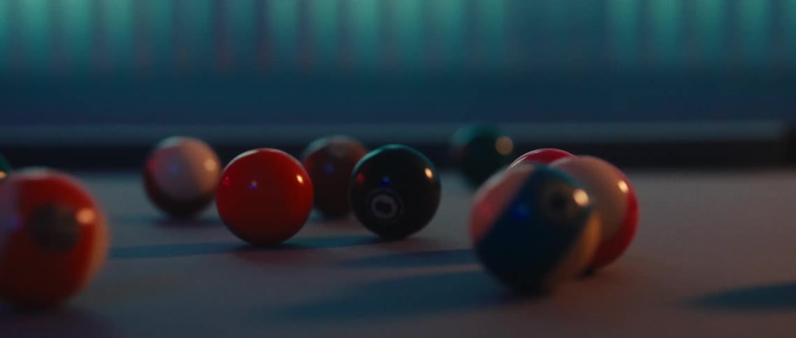 A row of colorful billiard balls is neatly racked on a dark pool table with the balls appearing vibrant against the subdued lighting the focus is on the balls themselves with the setting providing a sense of anticipation for a game