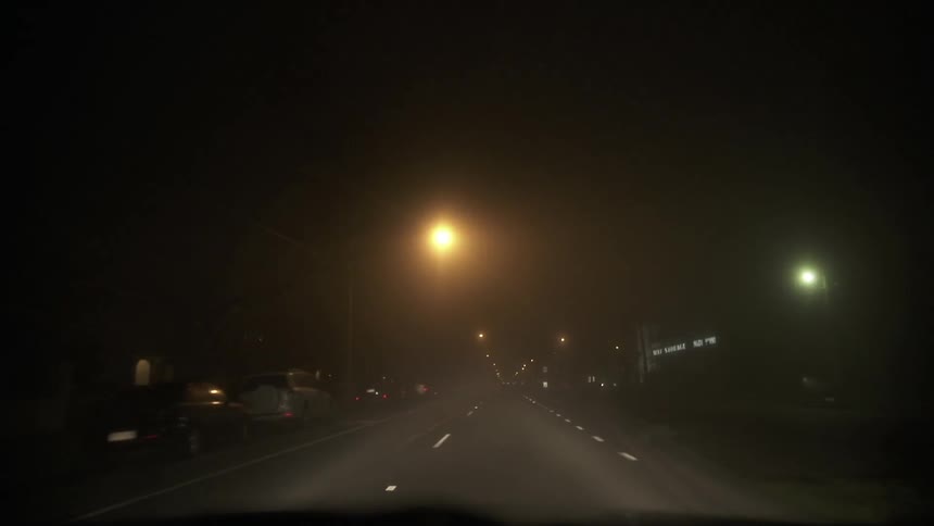 Vehicle driving down a dark road