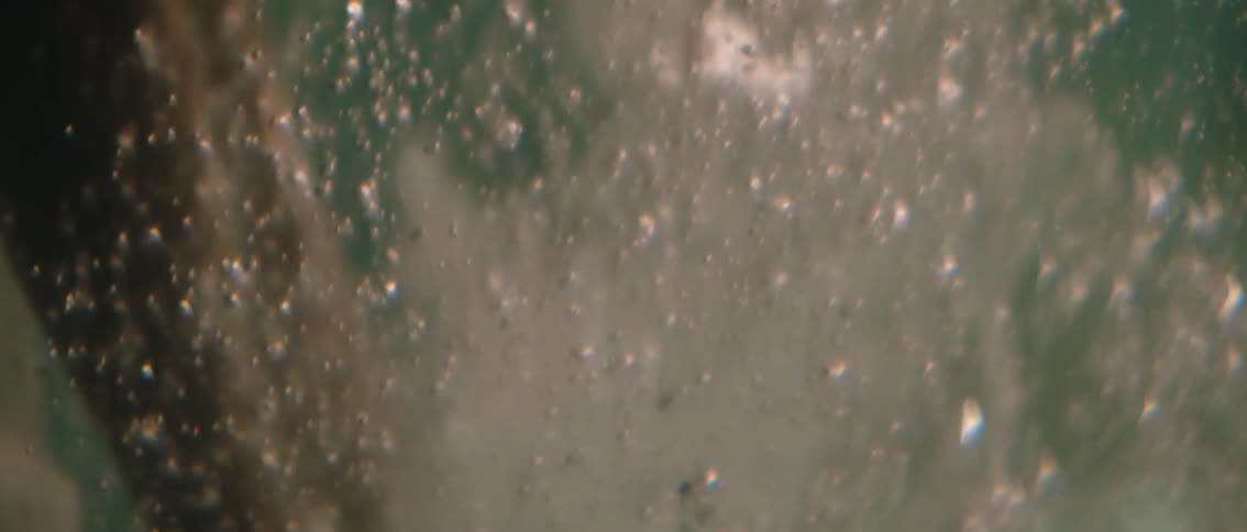 The video displays an abstract shot of bubbles rapidly rising through water creating a lively and effervescent visual effect the continuous upward movement and varying sizes of the bubbles suggest agitation or boiling filling the frame with dynamic mot
