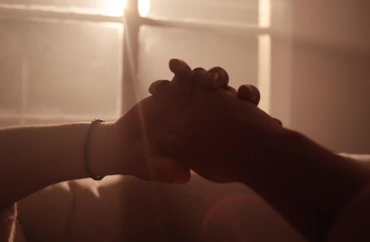 Couple holding hands lying on the sofa