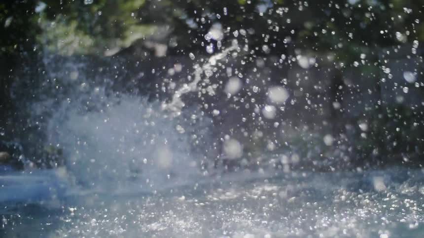 Water splashes near a boy in a pool