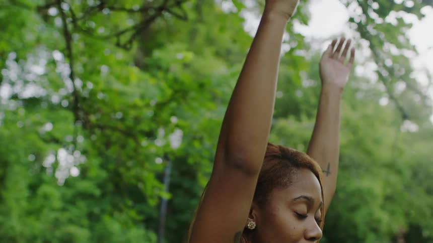 A woman is doing yoga in a park